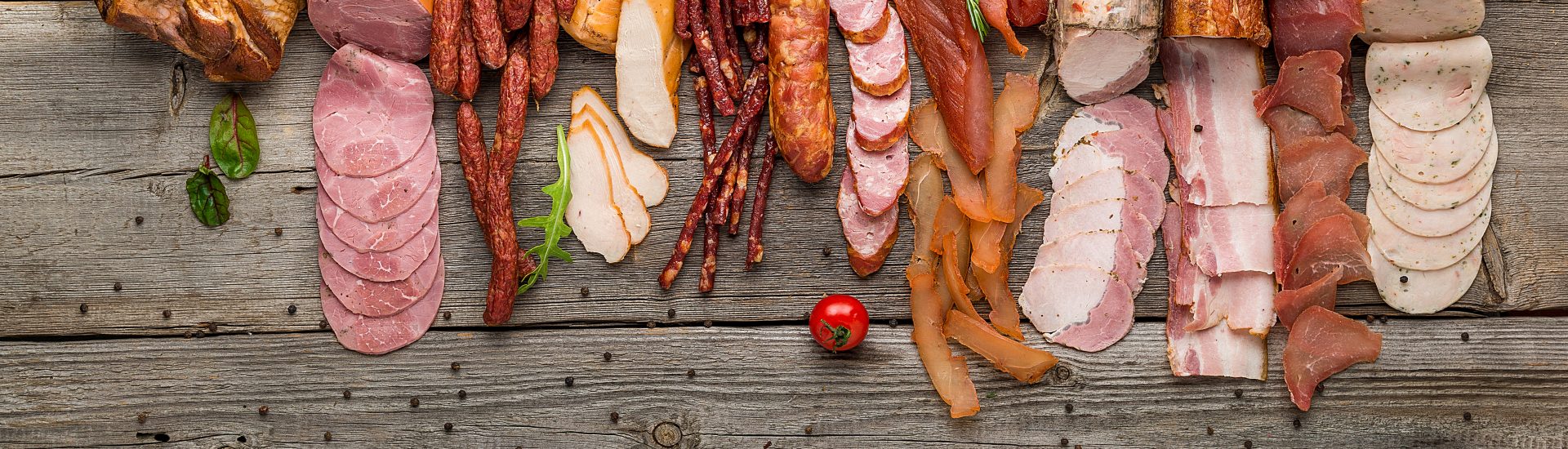 Assortment of cold meats, variety of processed cold meat products. On a wooden background