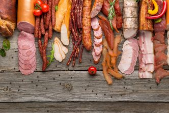 Assortment of cold meats, variety of processed cold meat products. On a wooden background